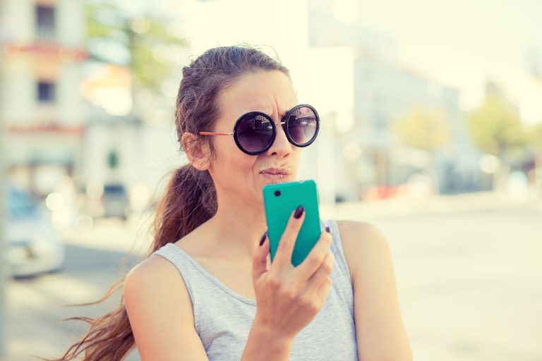 woman having trouble reading her mobile phone